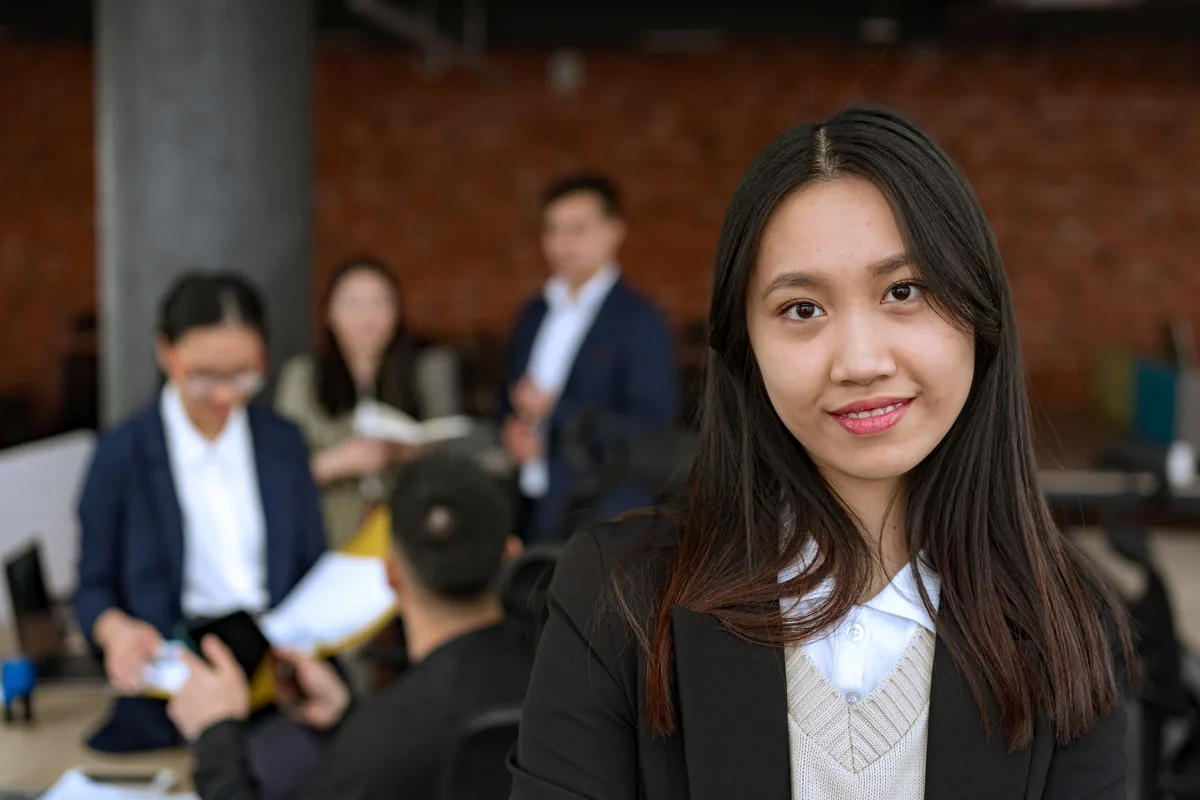 นักธุรกิจหญิงในออฟฟิศสมัยใหม่ ทบทวนขั้นตอนงานบนแล็ปท็อปก่อนออกแบบ AI Automation และ Workflow Automation
